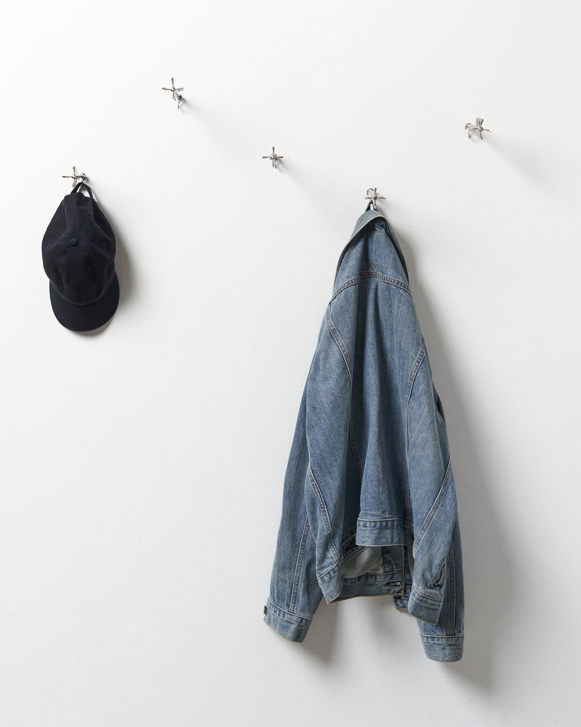 Five Brass Arrow Wall Hooks - image 10 - front view of the arrow wall hooks - a cap hanging from one, a jean jacket another