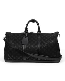 Black Light Up Keepall Bandoulière 50 - image 2 - back of bag showing the black embossed material, carrying strap and luggage label