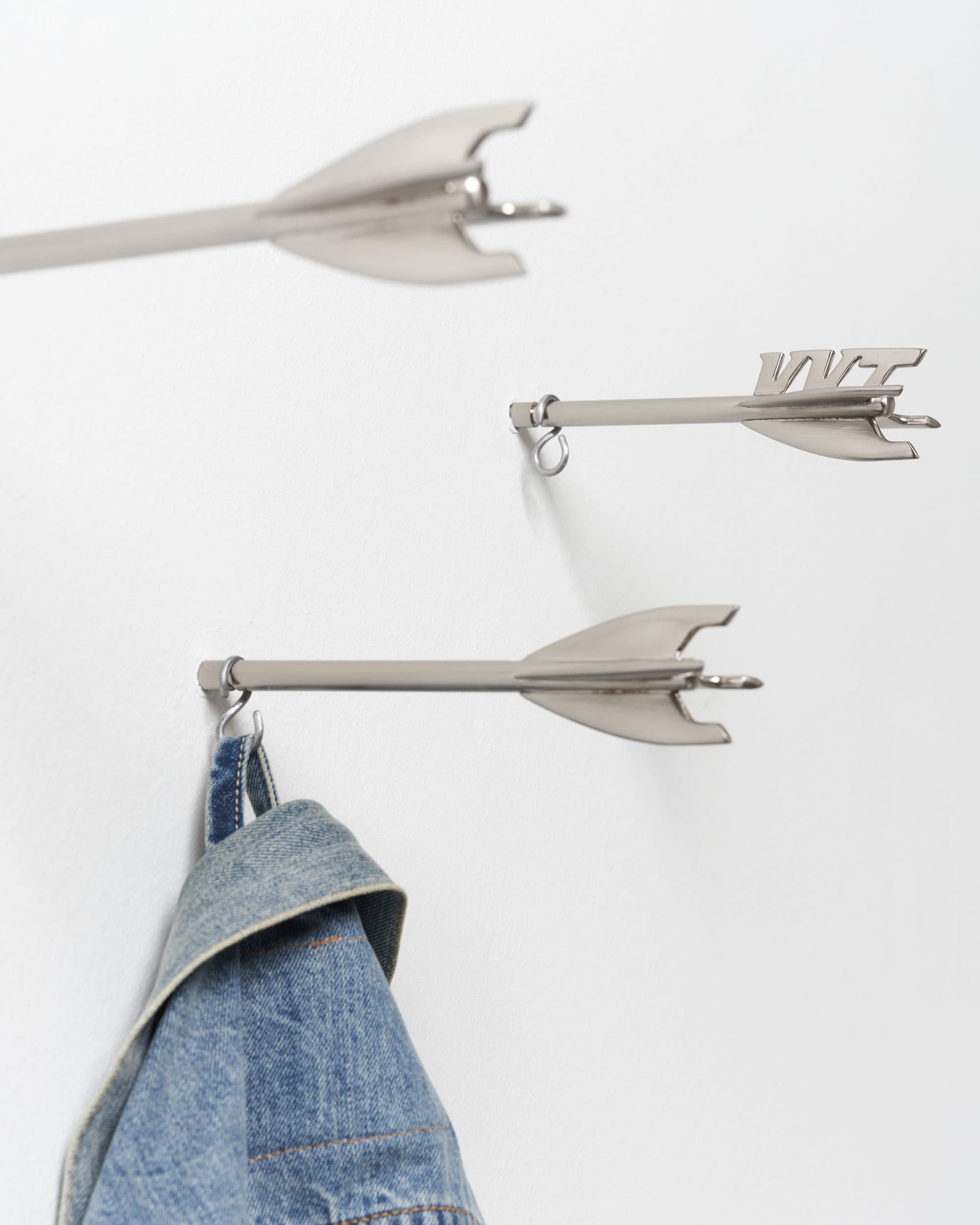 Five Brass Arrow Wall Hooks - image 9 - side view of three arrow wall hooks, a jean jacket hung on one of the hooks