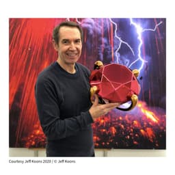 Image of Artist Jeff Koons holding his artwork
