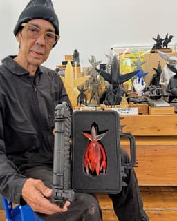 Patient Zero - Resinator - image 01b - artist FUTURA 2000 holding the open flight case containing the figure in their studio with other figures in the background
